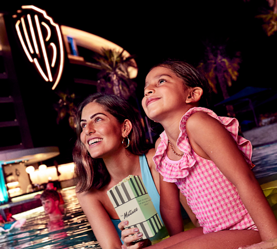 guests in the outdoor pool watching a movie