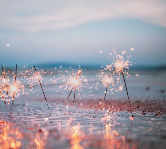 Closeup of lit sparklers on the beach