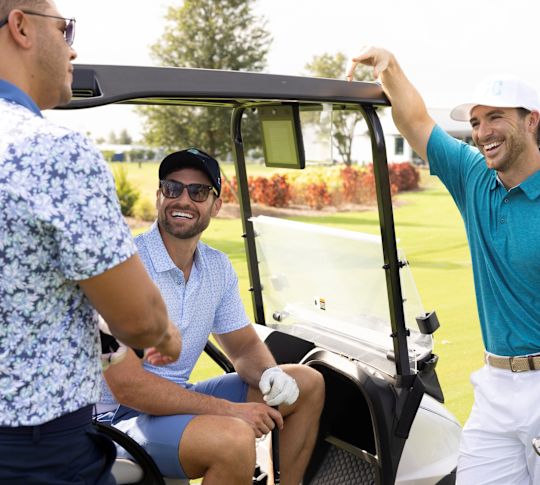 Tři muži se připravují na golf