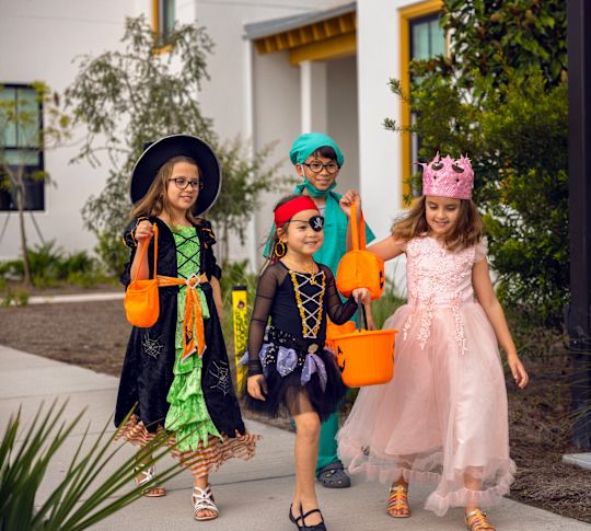 A group of children in costumes outside
