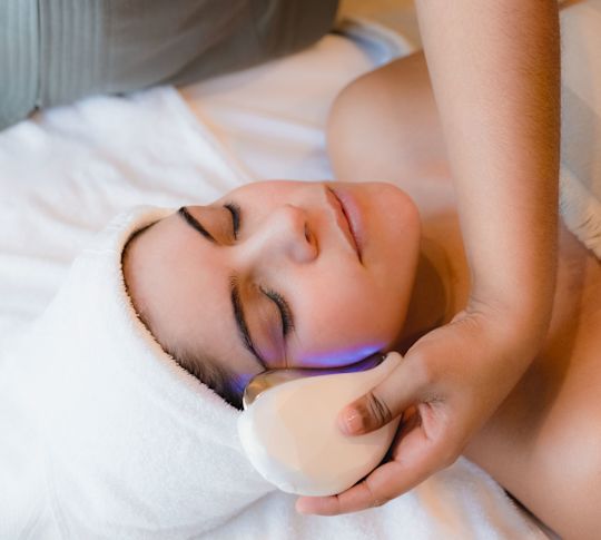 Femeie bucurându-se de un masaj facial la spa