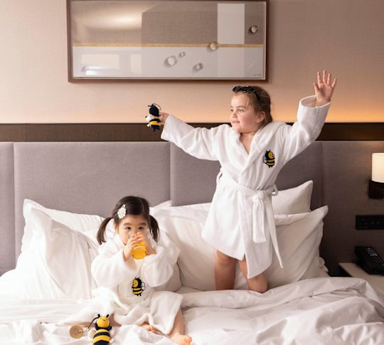 Twee meisjes spelen in bed in een kamer