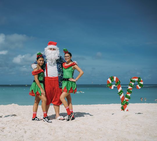 Sahilde Elf Olarak Giyinmiş İki Kız ile Sahilde Noel Baba Maddesi