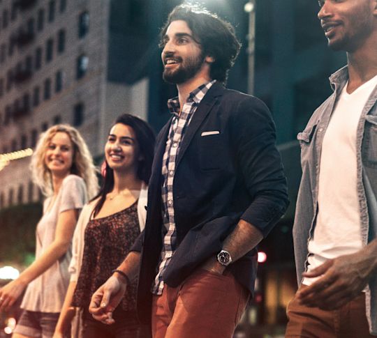 two young women and two young men are walking through Downtown  Austin at night
