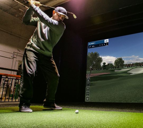 Ein Mann, der Full Swing Golf Simulator spielt