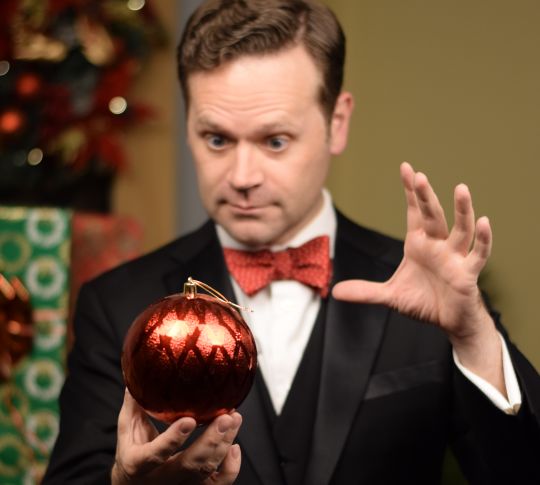 Dennis Watkins Holding a Decorative Christmas Ball