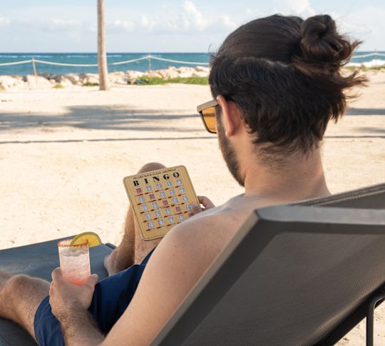 Kumsalda Çim Sandalyesi Üzerinde Tombala Oynayan Adam