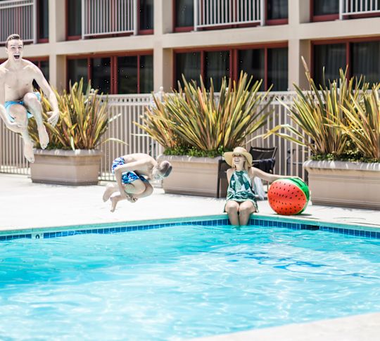 oaspeți sărind în piscina exterioară