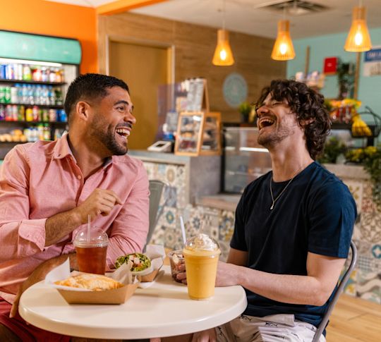 Man Laughing and Enjoying Food and Drinks at Ice Cream and Cookie Company