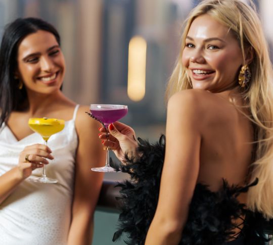 women holding drinks on outdoor patio