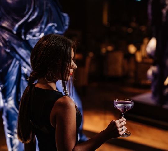 Woman standing holding cocktail