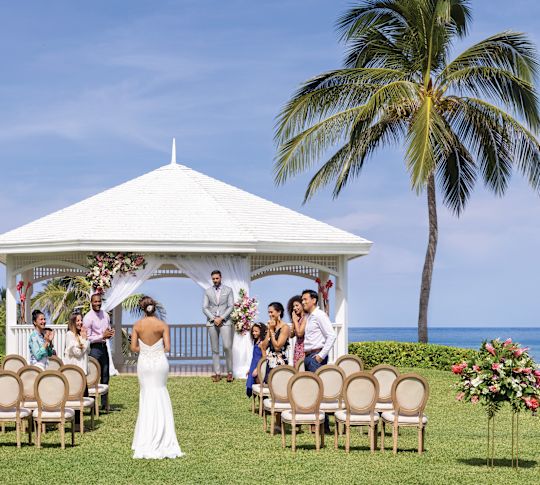 All-inclusive resort in Jamaica Happy just-married couple exiting ceremony at Hilton Rose Hall Resort & Spa