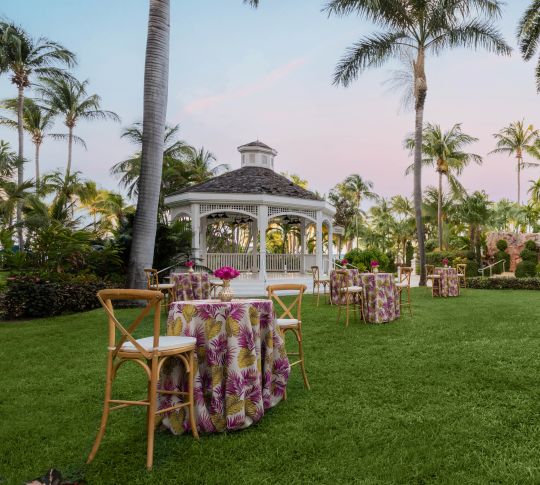 Outdoor venue set up with decorated tables and chairs for an event