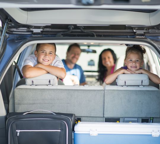 Family Smiling through Back of Car