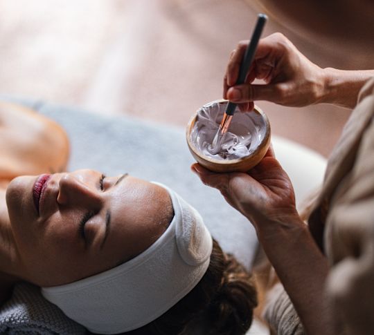 Woman receiving facial treatment at spa
