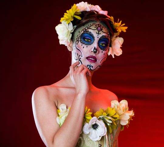 woman with dia de los muertos sugar skull painted on her face