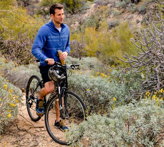 Мужчина ездит на велосипеде по горному пассу