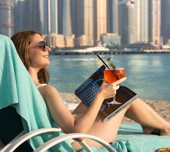 Woman at the Beach Having a Drink at Jones the Grocer with a View of the City in Background