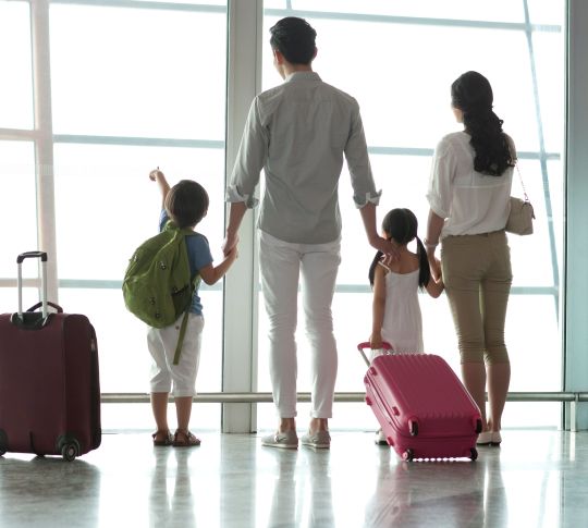 Family looking out window at airport