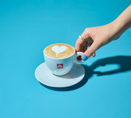 En kvinnas hand håller en kopp kaffe