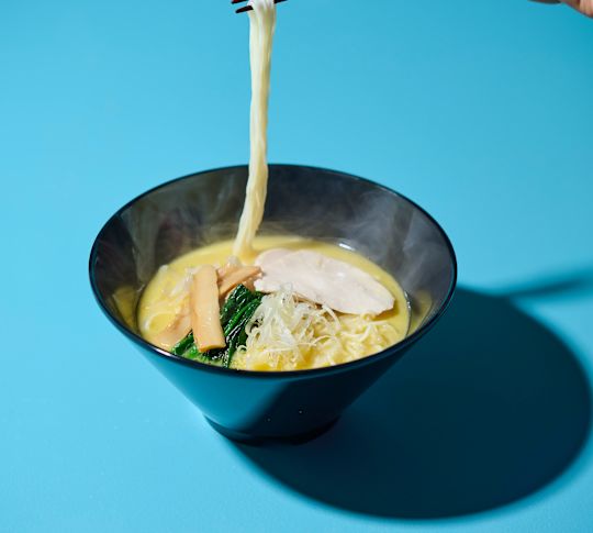 En kvinnas handhållna nudlar med hackpinnar