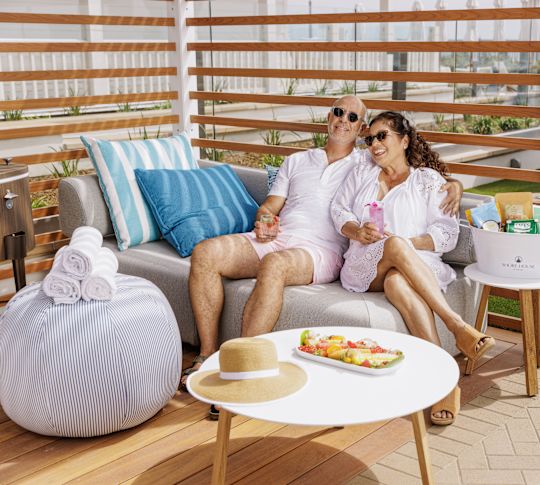 couple sitting in cabana with drinks and food
