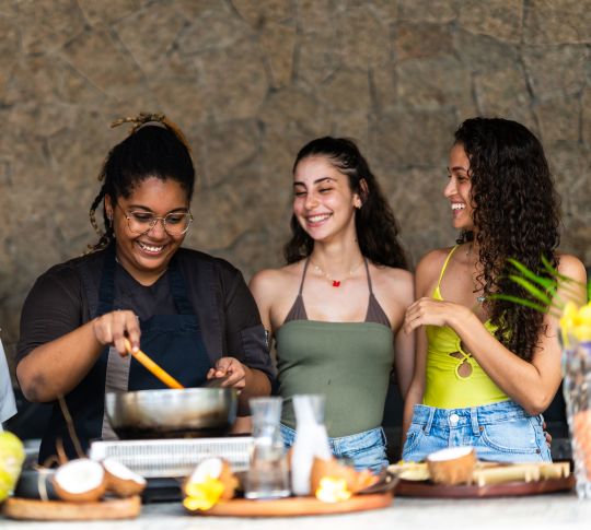 Three women watching a cooking demonstration