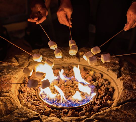 açık ateşte marshmallow kızartan kişi