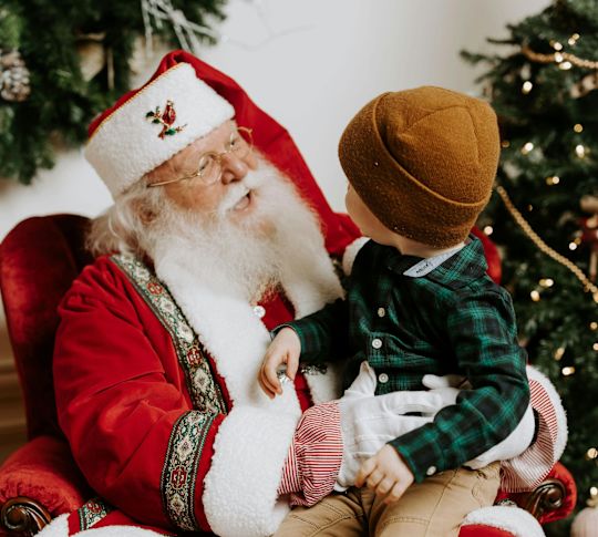 A Little Boy Is Taking a Photo with Santa