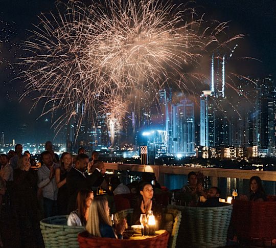 Barfly by Buddha-Bar outside fireworks over head of people at outdoor tables