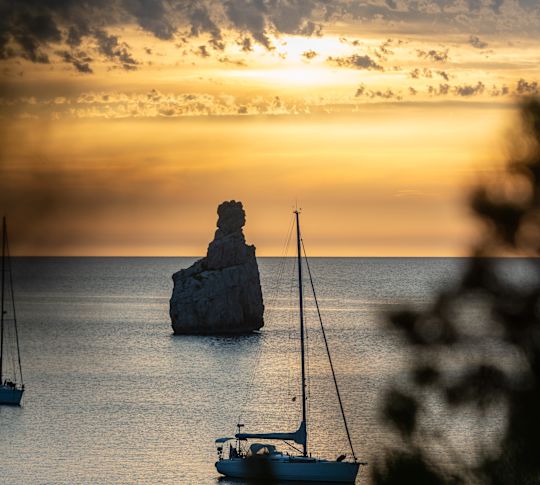 Stockbild des Boots auf dem Wasser bei Sonnenuntergang im Club Cala San Miguel