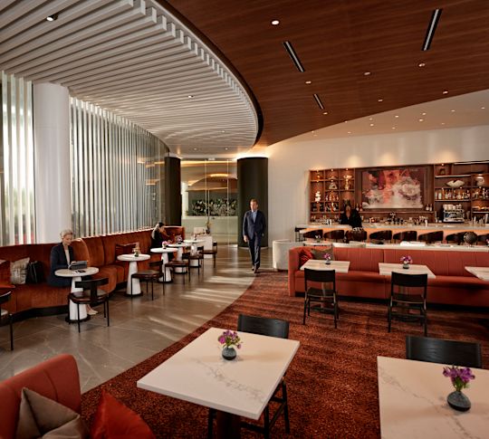 Bar area with man walking between tables and chairs