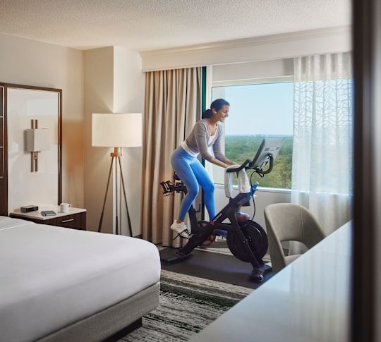 Mulher exercitando-se em uma bicicleta ergométrica em seu quarto