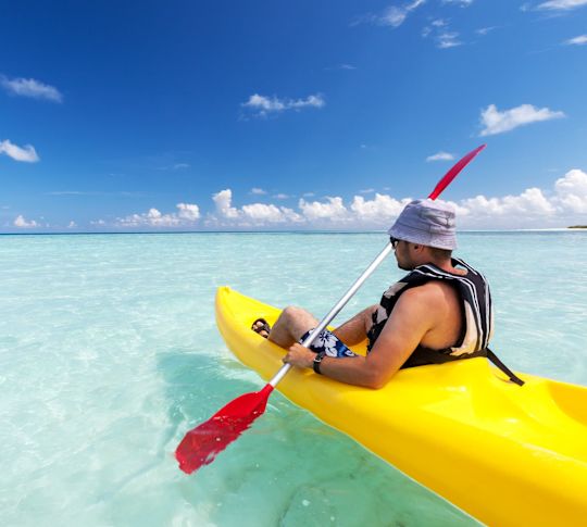 Man kayaking in the crystal clear ocean
