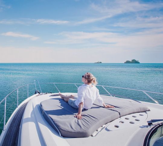 Woman gazing over the ocean at the helm of a boat