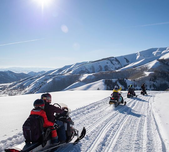 Persone in motoslitta su una montagna