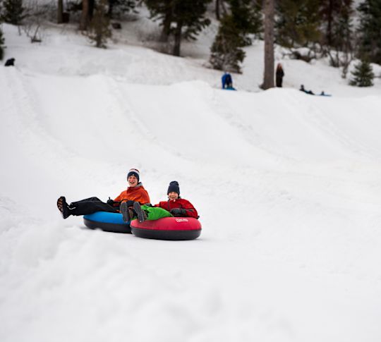 Teenagers Enjoying Tubing on a Snowy Slope