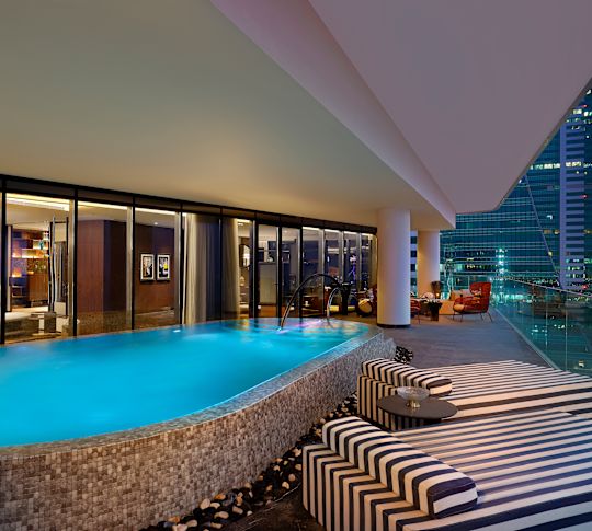 teras suite tamu, kolam renang, kursi lounge, pemandangan kota