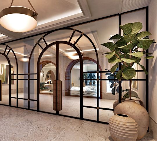 Hotel lobby corridor with glass partitions, pendant lights, potted plants, and stone tile flooring