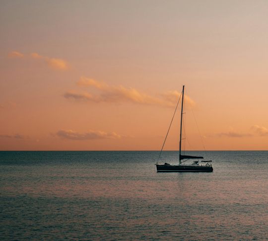 Aerial view of a sailboat on the Ionian Sea during a sunset tour.