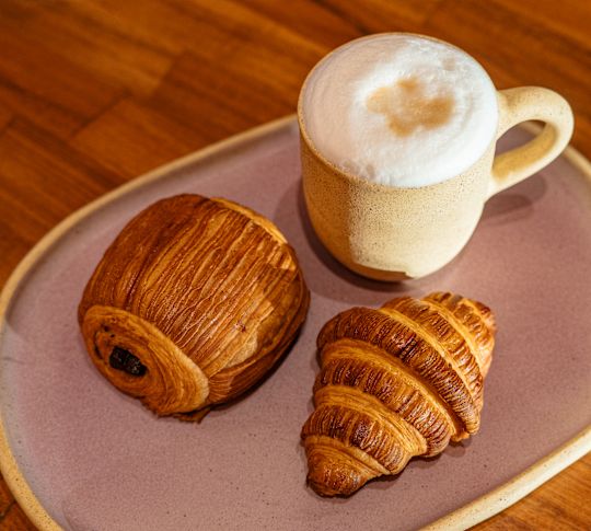 Kaffee und Croissant auf einem Teller im Restaurant Cafetal