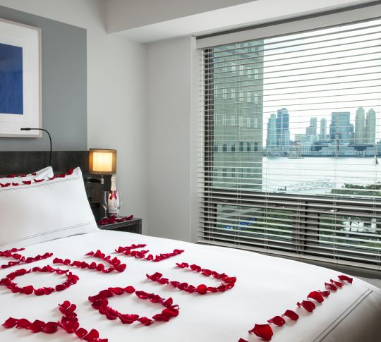 guest room bed with floral arrangement spelling I love you on bed