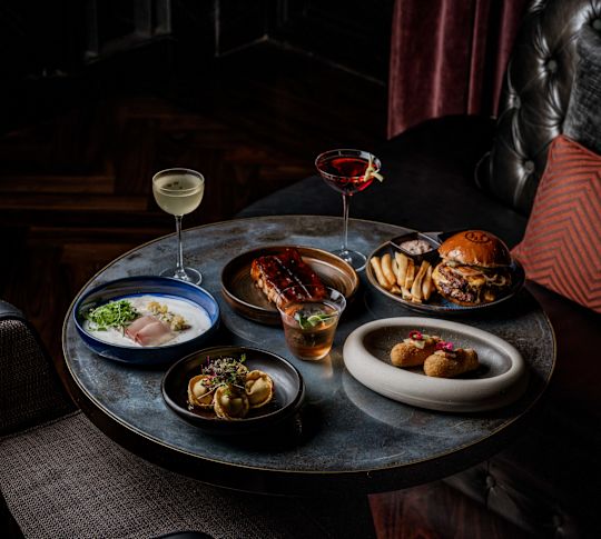 Food and drink displayed on table with comfortable chairs