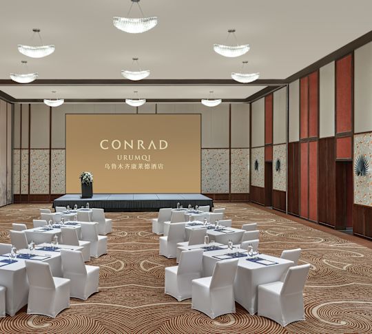 Ballroom with round tables, chairs and projector screen