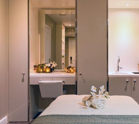 Spa treatment room with table and sink.