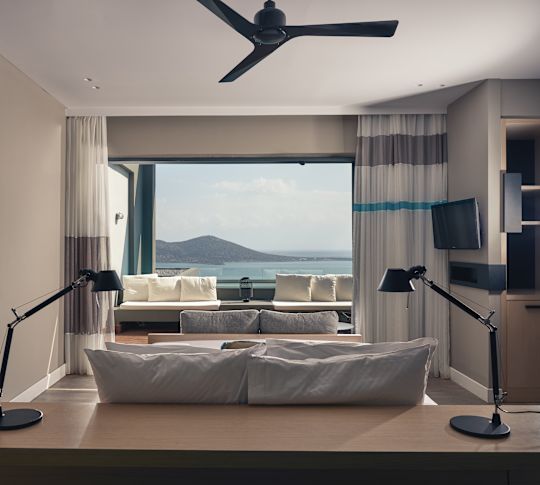 Sapphire Zen suite's bed facing large picture windows with a sea view.