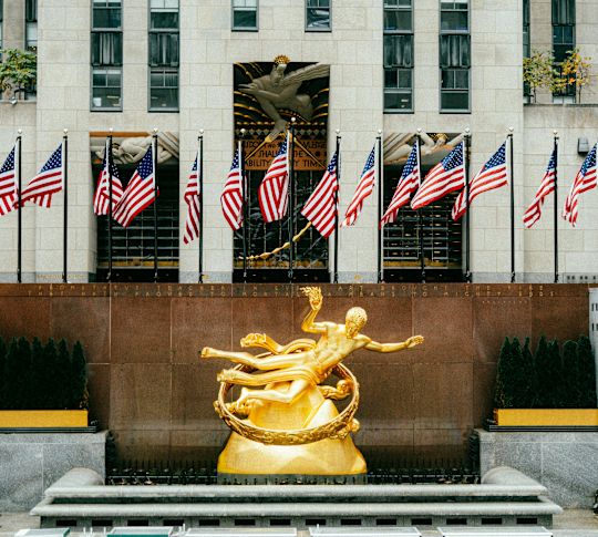 Hotel Exterior with a Golden Statue and American Flags