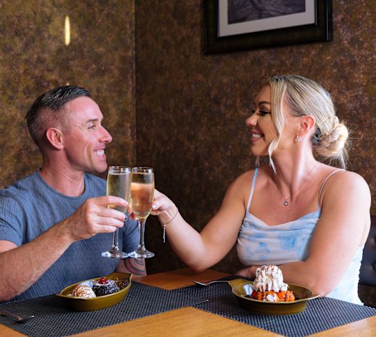 Двойка, която пие напитки и десерт в ресторант Brasserie - преход