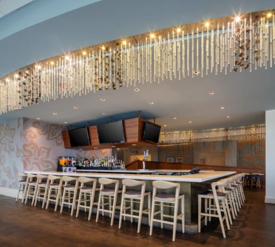 Vaatebaari ja grilli, baarialue, jossa televisiot ja riippuvat valot