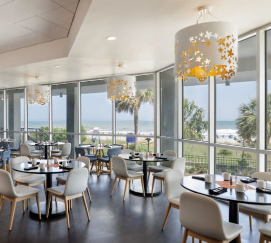 Kallis Bar & Grill -ravintolasali, josta avautuu ikkunanäkymä rannalle